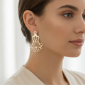 Filigree drop earring worn on model ear in soft natural light